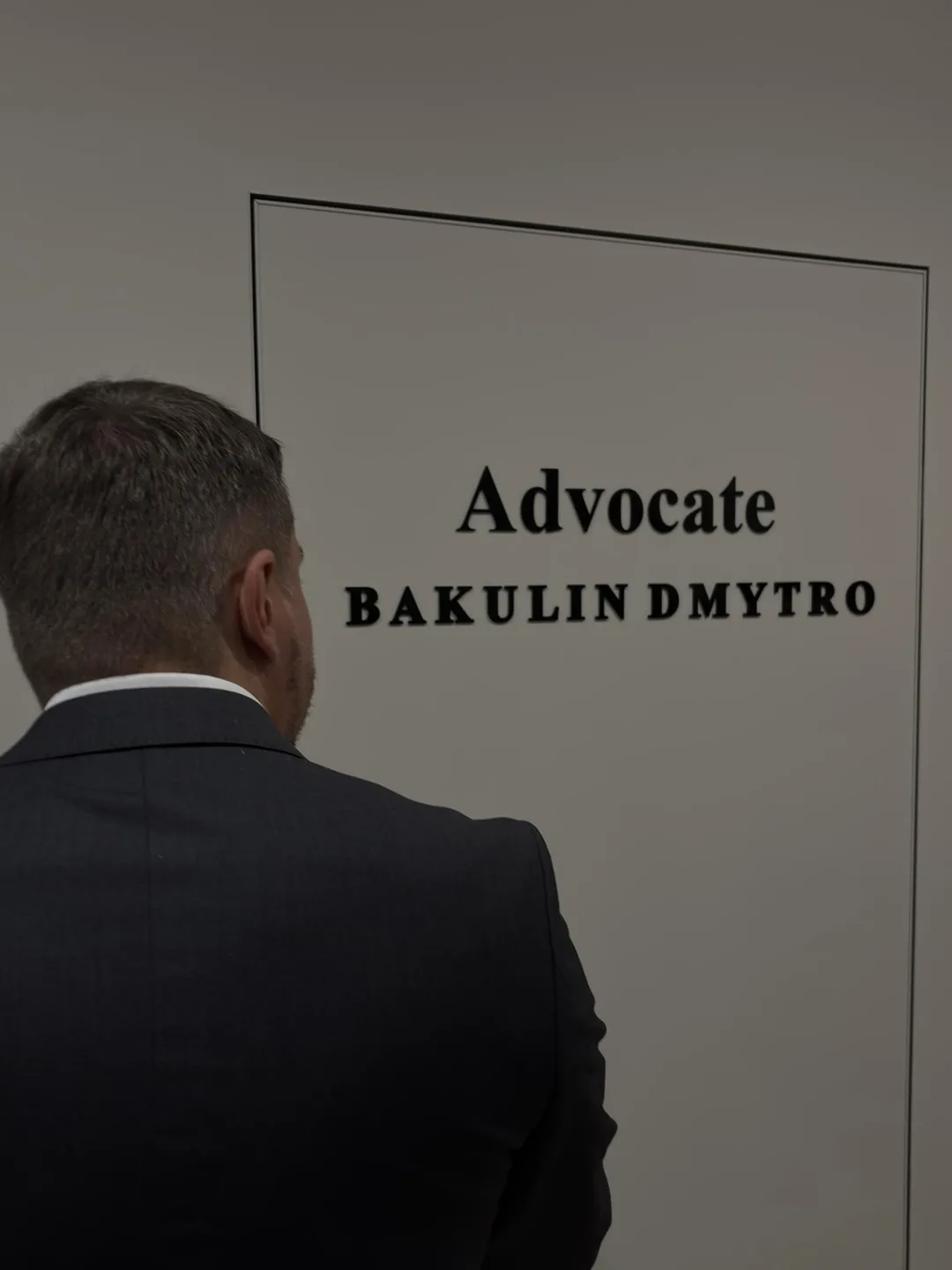 Дмитро Бакулін перед дверима кабінету з табличкою «Advocate Bakulin Dmytro»